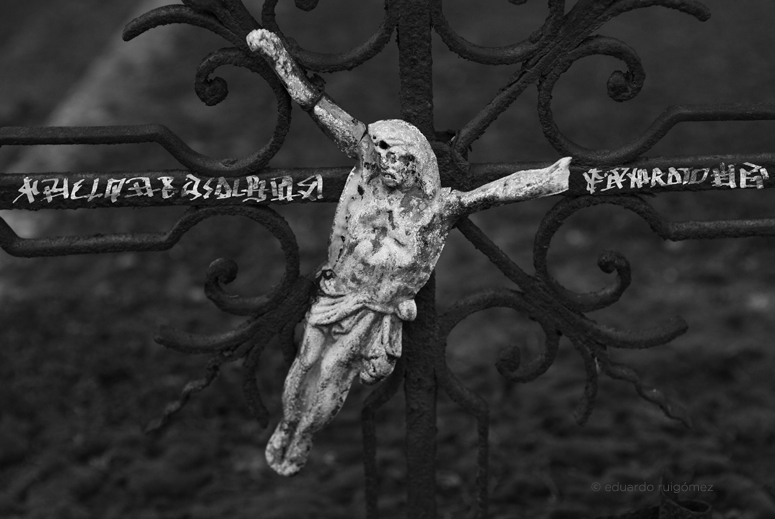 Tumba con crucifijo roto ladeado.