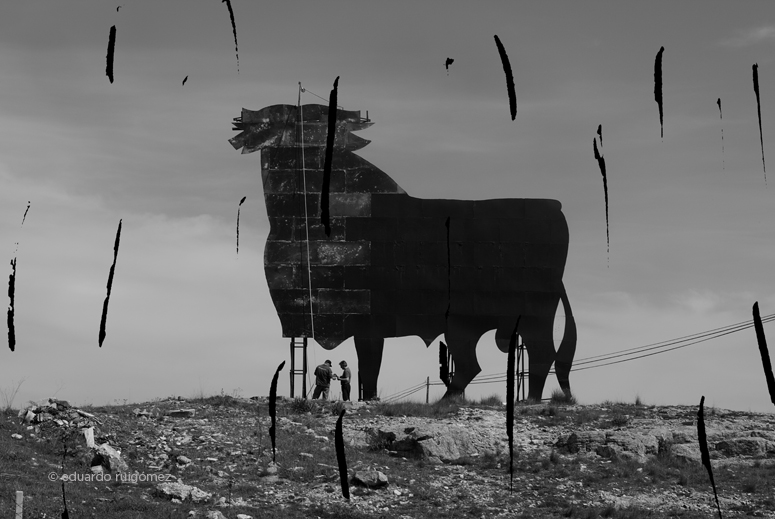 Obreros restaurando un Toro de Osborne dañado por la acción del viento y la lluvia.