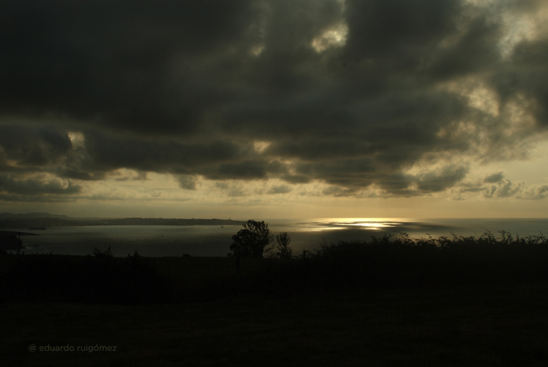 Bahía oscurecida por las nubes negras del atardecer