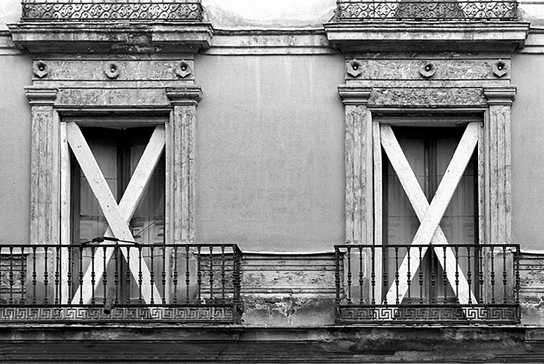 Ventanas apuntaladas en una fachada de una casa vieja.