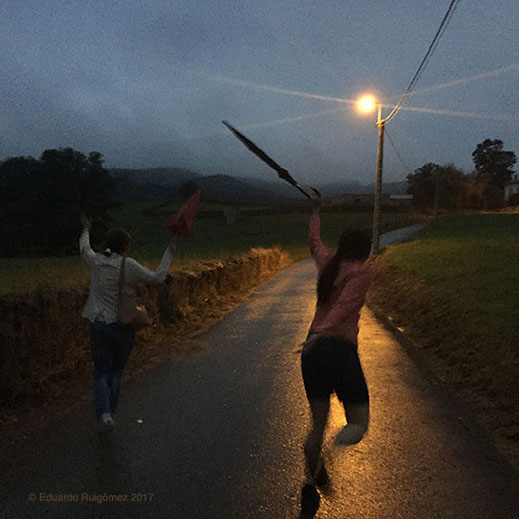 Dos mujeres caminan de forma alegre por un camino en el campo.