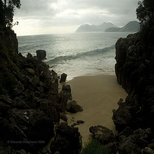 Unas rocas de una cala con el fondo del mar y la puesta del sol