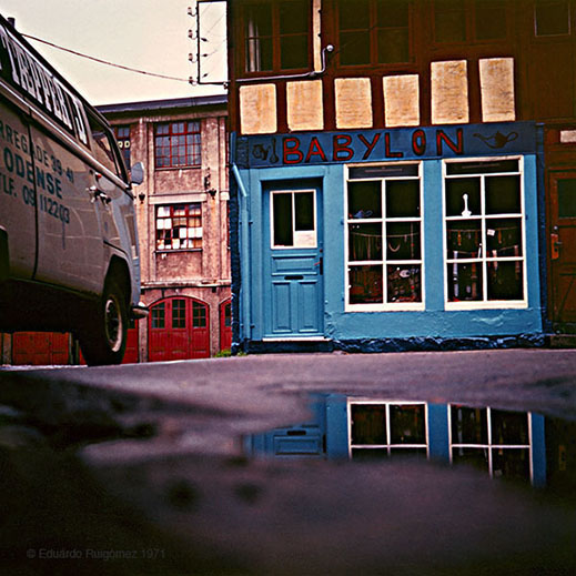 Furgoneta de carga en una plaza llena de charcos en el suelo.