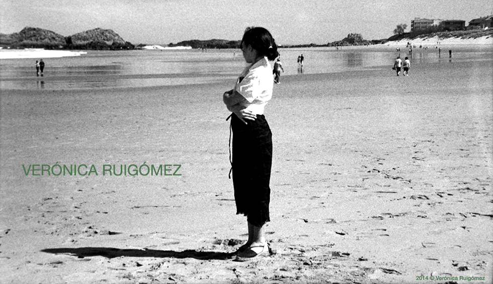Mujer en una playa mirando hacia el mar